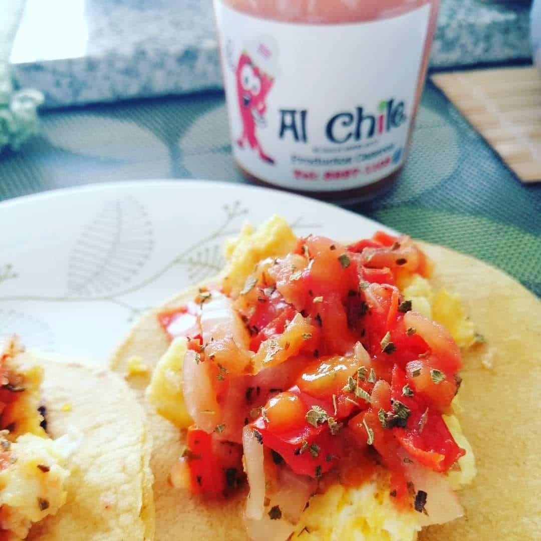 Plato con pasta y salsa Alchile, decorado con cilantro y limón